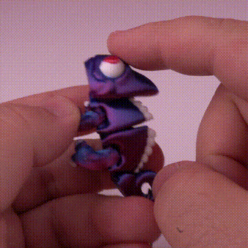 Manos jugando con figura colorida de camaleón