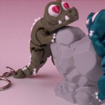 Llaveros de dinosaurios escalando una roca gris