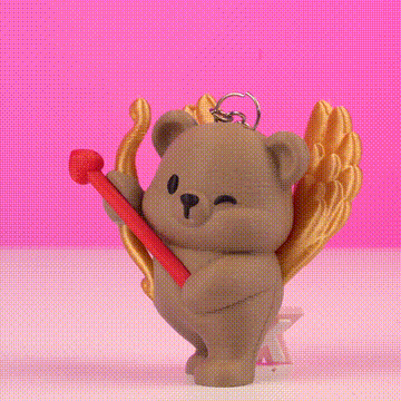 Osito con alas doradas sosteniendo un bastón rojo