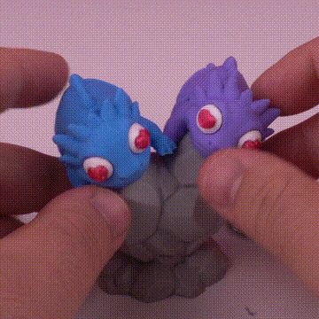 Manos moldeando criaturas de plastilina de colores