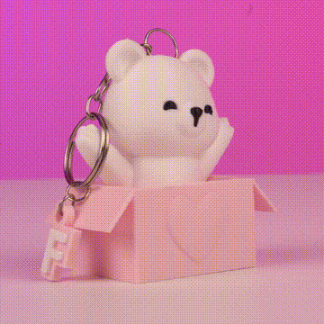 Llavero de oso blanco saliendo de caja rosa