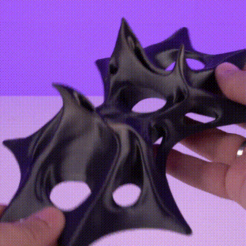 Manos estirando goma negra con agujeros