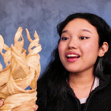 Persona sorprendida mirando escultura tallada en madera.